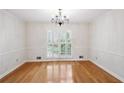 Bright dining room boasts hardwood floors, elegant chandelier, and french doors to the exterior at 2611 Leeshire Ct, Tucker, GA 30084