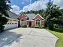 Charming brick home featuring a two-car garage, a well-manicured lawn, and a spacious driveway at 1902 Commons View Cir, Snellville, GA 30078