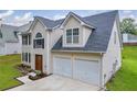 View of a two-story home showcasing the attached two-car garage and a well-maintained lawn at 4092 Arabian Way, Snellville, GA 30039
