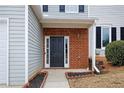 Welcoming front door with black paint and brick accents, framed by manicured landscaping at 132 Timber Mist Ln, Lawrenceville, GA 30045