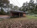 Side view of cozy brick home with covered carport and surrounding greenery at 2369 Christian Cir, Covington, GA 30016