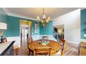 Dining room with teal accent wall, chandelier, and hardwood floors create a inviting space for meals at 1346 Wind Chime Ct, Lawrenceville, GA 30045