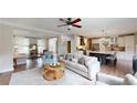 Open-concept living room and kitchen featuring hardwood floors, modern lighting, and ample space for entertaining at 1346 Wind Chime Ct, Lawrenceville, GA 30045
