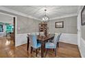 Traditional dining room with hardwood floors, wainscoting, and a modern chandelier at 5804 Fairwood Nw Cir, Acworth, GA 30101