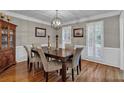 Dining room featuring hardwood floors, wainscoting, shuttered windows, and updated lighting fixture at 5804 Fairwood Nw Cir, Acworth, GA 30101