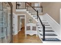 Bright foyer with hardwood floors, a staircase, decorative bench, and large glass paneled front door at 5804 Fairwood Nw Cir, Acworth, GA 30101