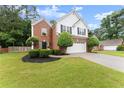 Charming two-story home with brick facade, manicured lawn, trimmed bushes, and a two-car garage at 1980 Heatherton Rd, Dacula, GA 30019