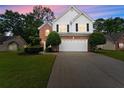 Charming two-story home featuring a brick and white exterior, landscaped yard, and an extended driveway at 1980 Heatherton Rd, Dacula, GA 30019