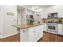 Kitchen with an island, stainless steel appliances, granite countertops, and wood floors at 11260 Havenwood Dr, Johns Creek, GA 30097