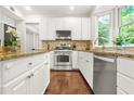 Modern kitchen features stainless steel appliances, tile backsplash, and wood floors at 11260 Havenwood Dr, Johns Creek, GA 30097
