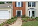 Inviting front entrance featuring a beautifully landscaped walkway, decorative plants, and brick accents at 2904 Masonwood Nw Dr, Kennesaw, GA 30152