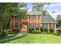 Charming brick home with a lush green lawn, mature trees, and classic architectural details at 4497 Windsor Oaks Dr, Marietta, GA 30066