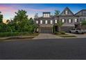 Well-manicured townhome with stone facade, two-car garage, and lush greenery in a tranquil setting at 1099 Heyward Way, Alpharetta, GA 30009