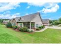 Beautiful home exterior showcasing a lush lawn and landscaping, plus covered porch with a ceiling fan at 2384 Tree Arbor Way, Marietta, GA 30064
