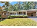 Inviting single-story brick home features a spacious front porch with decorative railings and an attached carport at 840 Hickory Sw Dr, Marietta, GA 30064