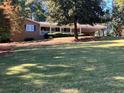 Charming single-story brick home with a long front porch, mature trees, and a large, well-maintained front yard at 840 Hickory Sw Dr, Marietta, GA 30064