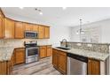 Kitchen with stainless steel appliances, wood cabinets, granite countertops, and hardwood floors at 3325 Castleberry Village Cir, Cumming, GA 30040