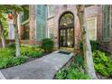 Beautiful brick building entrance with arched doorway, accented with green shutters and lush landscaping at 124 Lafayette Ne Dr # 4, Atlanta, GA 30309