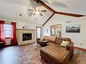 Comfortable living room with brick fireplace, hardwood floors, and large sectional sofa at 4812 Shallow Creek Nw Dr, Kennesaw, GA 30144
