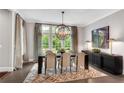 Elegant dining room with a large window, contemporary chandelier, and chic decor at 6445 Lucent Ln, Atlanta, GA 30328