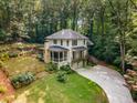A charming white two-story home featuring manicured lawn and wooded surroundings at 1461 Bubbling Creek Ne Rd, Brookhaven, GA 30319
