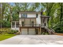 Two-story home with a two-car garage, beautiful landscaping, and a wooded backdrop at 1461 Bubbling Creek Ne Rd, Brookhaven, GA 30319