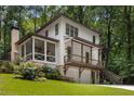 Two-story home with white siding, a screened-in porch, a walk-out basement, and a two-car garage at 1461 Bubbling Creek Ne Rd, Brookhaven, GA 30319