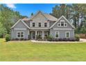 Inviting two-story home with stone accents, manicured lawn, and mature landscaping at 33 Vinery Ct, Sharpsburg, GA 30277