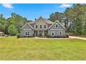Charming two-story home with stone accents, lush lawn and mature landscaping at 33 Vinery Ct, Sharpsburg, GA 30277