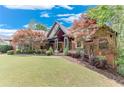 Charming two-story home with beautiful landscaping, a well-manicured lawn, and brick exterior at 5623 Brendlynn Dr, Suwanee, GA 30024