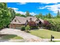 Charming two-story home with manicured lawn, brick and stone exterior, and a long driveway at 5623 Brendlynn Dr, Suwanee, GA 30024