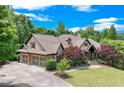 Charming two-story home with manicured lawn, brick and stone exterior, and three-car garage at 5623 Brendlynn Dr, Suwanee, GA 30024