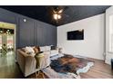 Stylish living room featuring modern wall paneling, hardwood floors, and a sleek, mounted TV at 1689 Camden Forrest Way, Riverdale, GA 30296