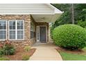 Inviting entryway showcasing a brick facade, covered porch with ceiling fan, and manicured garden beds at 3734 Villa Springs Cir, Powder Springs, GA 30127