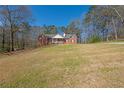 Sprawling front yard showcases a brick home with a cozy front porch and ample space at 5826 Little Mountain Dr, Ellenwood, GA 30294
