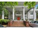 Grand home featuring a welcoming front porch with prominent columns, steps, and a balcony above the red front door at 893 Piedmont Ne Ave # 3, Atlanta, GA 30309