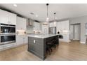 Gourmet kitchen with large center island, stainless appliances, and ample white cabinets at 4105 Woodwind Dr, Cumming, GA 30028