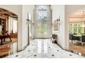 Spacious foyer with marble floors, ornate lighting, and adjacent dining area at 115 Cross Roads Ct, Atlanta, GA 30327