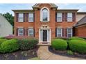 Close up of a charming brick home with a manicured lawn and pathway to front door at 199 Eastham Ct, Suwanee, GA 30024