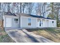 Single-story home with light blue siding, white trim, and a long driveway leading to the front entrance at 2216 Marbut Farms Trce, Lithonia, GA 30058