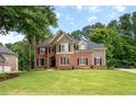 Elegant two-story home with manicured lawn and mature trees in a serene setting at 6061 Meridian Nw Dr, Acworth, GA 30101