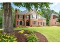 Charming two-story home with a lush green lawn and colorful flowerbeds at 6061 Meridian Nw Dr, Acworth, GA 30101