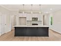 Modern kitchen with an island, white cabinets, stainless steel appliances, and hardwood flooring at 101 Priestwood Ln, Acworth, GA 30102
