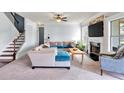 Comfortable living room with a fireplace, large windows, and a staircase at 2239 Noelle Pl, Powder Springs, GA 30127