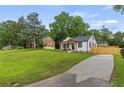 Landscaped front yard with driveway, white house with black trim at 528 Allendale Dr, Decatur, GA 30032