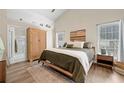 Spacious main bedroom with vaulted ceilings, wood floors, ensuite bathroom, and natural light at 1865 Morgans Run Trl, Buford, GA 30519