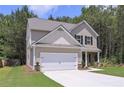 Charming two-story home showcasing a well-manicured lawn and a two-car garage surrounded by lush greenery at 48 Beaver Pt, Villa Rica, GA 30180