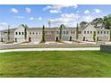 Street view of multiple new gray, brick, and white townhomes with attached garages and professionally maintained lawns at 105 Priestwood Ln, Acworth, GA 30102