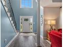 Inviting home foyer with a two-story ceiling, wood floors, grand staircase, and abundant natural light at 340 Chandler Ct, Sugar Hill, GA 30518