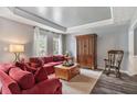 Comfortable living room with lots of natural light, a decorative ceiling, a large cabinet, and red sofas at 340 Chandler Ct, Sugar Hill, GA 30518